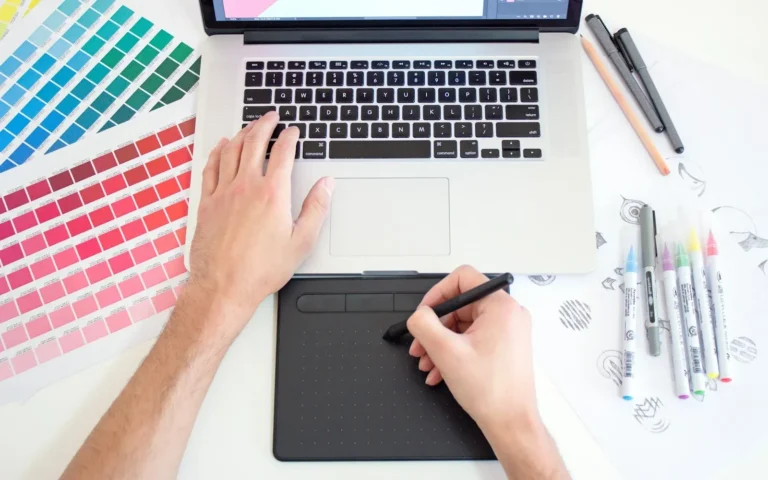Designer using a drawing tablet and colour swatches for a Divi website
